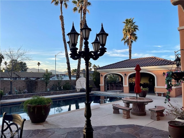 view of swimming pool with fence, a mountain view, a fenced in pool, and a patio