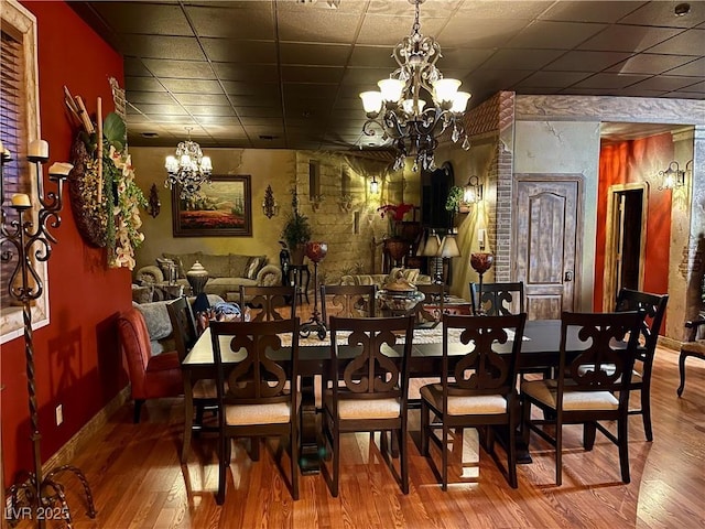 dining area featuring baseboards, a chandelier, and wood finished floors