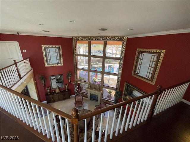 staircase with visible vents, ornamental molding, and a glass covered fireplace