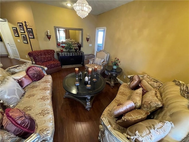 living room featuring an inviting chandelier, baseboards, and wood finished floors