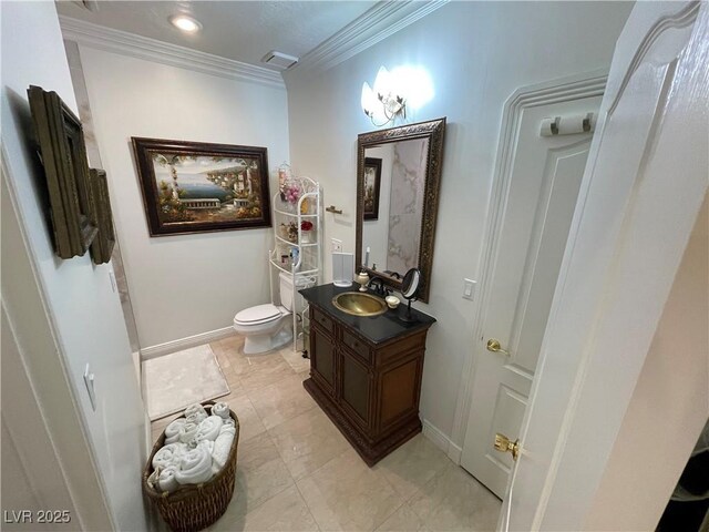 bathroom featuring ornamental molding, vanity, toilet, and baseboards