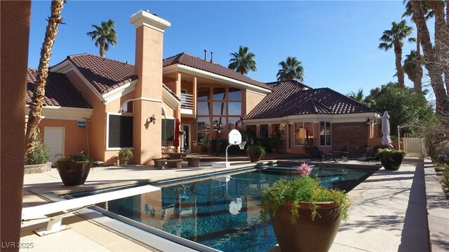 view of swimming pool featuring a pool with connected hot tub and a patio