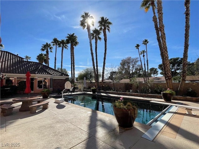 view of swimming pool featuring a patio area, a fenced backyard, a diving board, and a fenced in pool