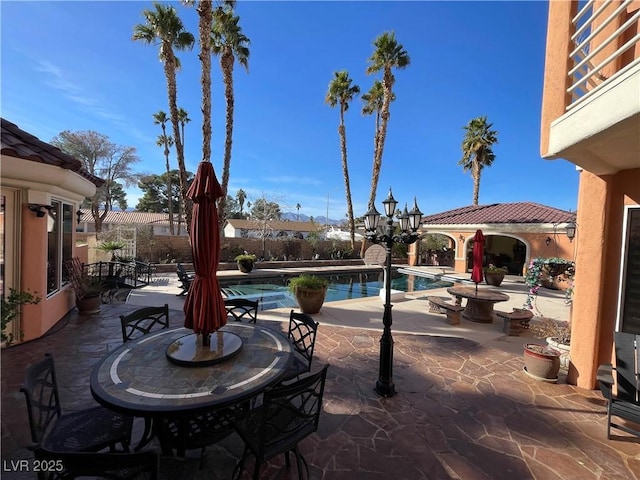 view of patio / terrace featuring fence, outdoor dining area, and a fenced in pool