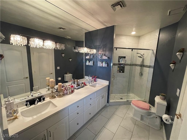 bathroom with toilet, a stall shower, marble finish floor, and a sink