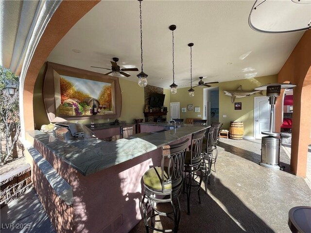 view of patio / terrace with an outdoor kitchen, a ceiling fan, a grill, outdoor wet bar, and a sink