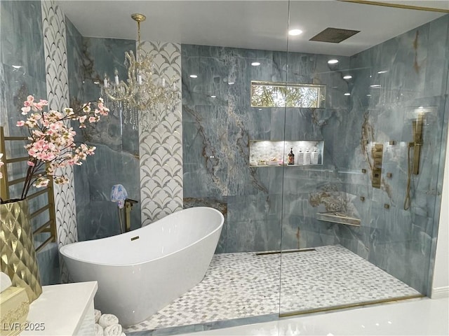 full bath featuring a freestanding bath, a marble finish shower, and tile walls