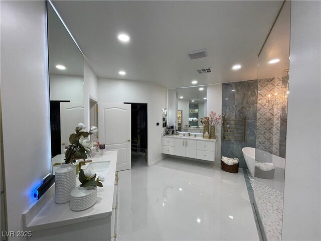 bathroom featuring two vanities, recessed lighting, visible vents, and a freestanding bath