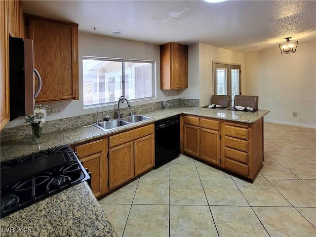 kitchen featuring light tile patterned floors, sink, black dishwasher, gas stove, and kitchen peninsula