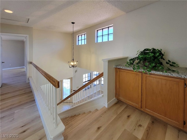 stairway featuring hardwood / wood-style flooring and a textured ceiling