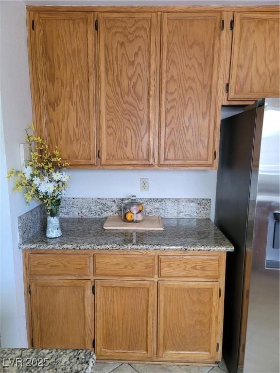 kitchen with stone counters and stainless steel fridge