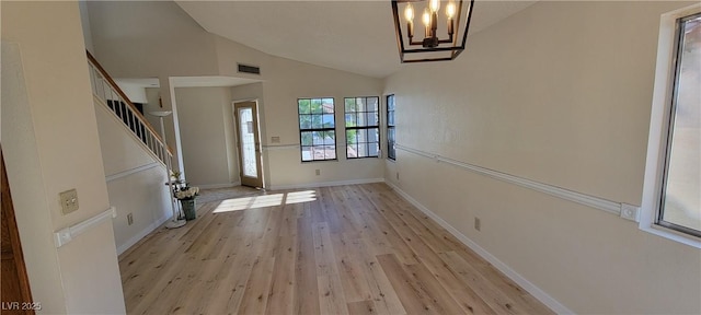 foyer with light wood-type flooring, lofted ceiling, and a notable chandelier