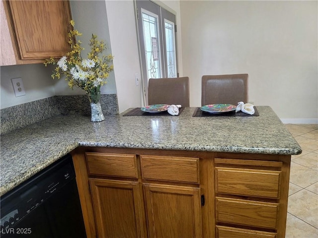 kitchen with light tile patterned flooring, dishwasher, and light stone counters