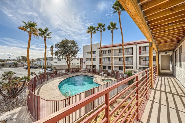 community pool with a patio and a residential view