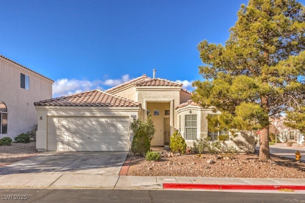 mediterranean / spanish-style home with a garage