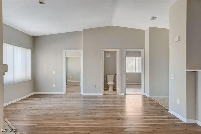 unfurnished living room with lofted ceiling and light wood-type flooring