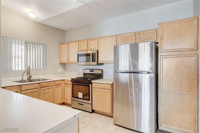 kitchen featuring stainless steel appliances, light brown cabinetry, sink, and light tile patterned floors