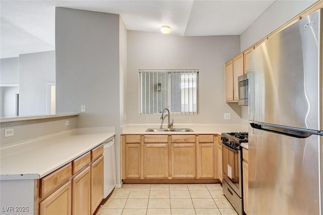 kitchen featuring light tile patterned flooring, light brown cabinetry, sink, kitchen peninsula, and stainless steel appliances