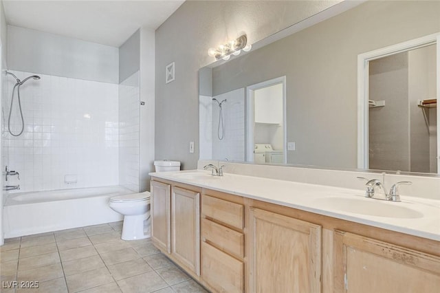 full bathroom featuring washing machine and clothes dryer, toilet, vanity, tiled shower / bath combo, and tile patterned flooring