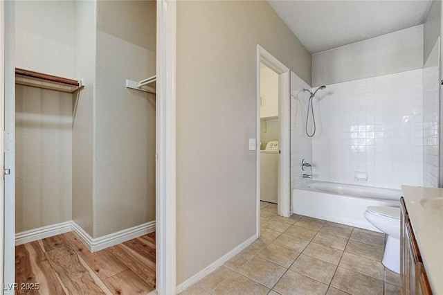 full bathroom featuring washer / clothes dryer, tiled shower / bath combo, vanity, tile patterned flooring, and toilet