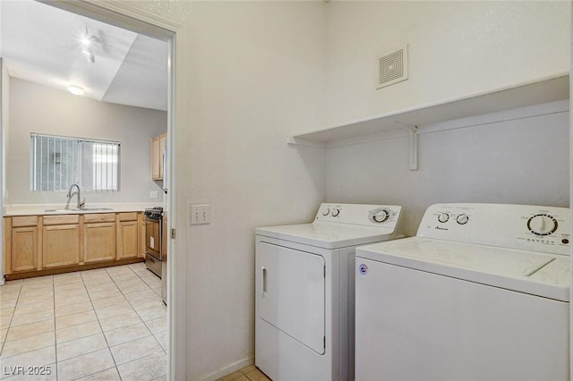 laundry room featuring light tile patterned flooring, sink, and independent washer and dryer