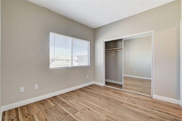 unfurnished bedroom with a closet and light hardwood / wood-style flooring