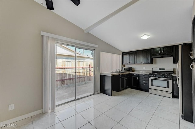 kitchen with light tile patterned floors, sink, ceiling fan, appliances with stainless steel finishes, and vaulted ceiling with beams