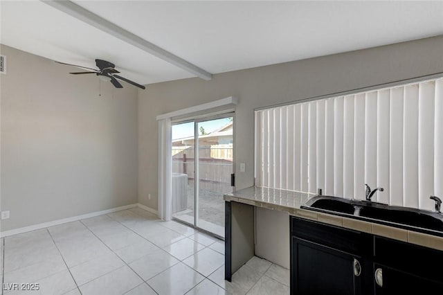 kitchen with sink, beam ceiling, ceiling fan, and light tile patterned flooring