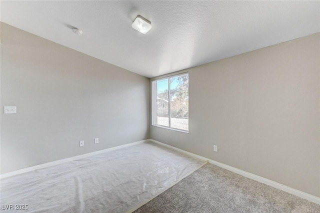 empty room with light carpet, lofted ceiling, and a textured ceiling