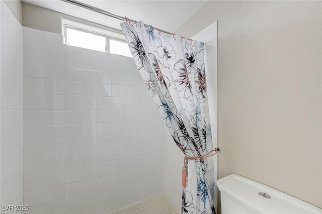 bathroom featuring curtained shower and toilet