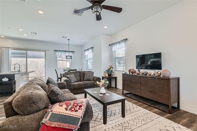 living room with dark wood-type flooring and ceiling fan