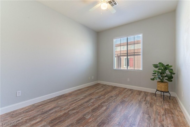 empty room with dark hardwood / wood-style floors and ceiling fan