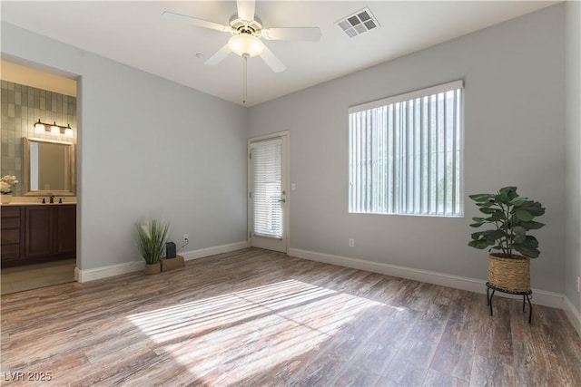 interior space with sink, ceiling fan, and light hardwood / wood-style flooring