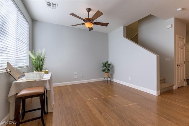 living area with wood-type flooring and ceiling fan