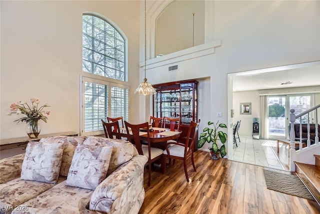 living room with a towering ceiling and wood-type flooring