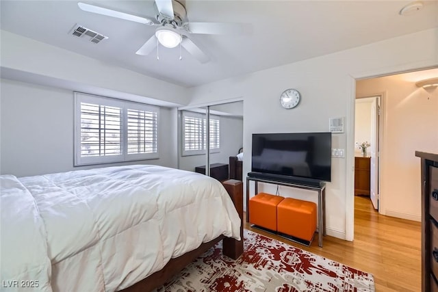 bedroom featuring hardwood / wood-style flooring, ceiling fan, and a closet