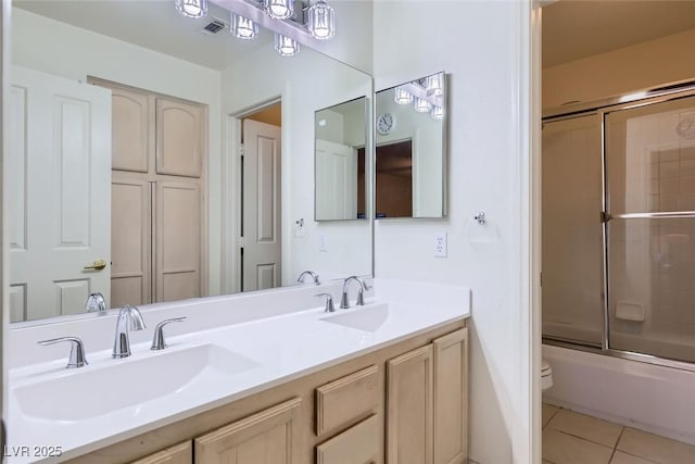 full bathroom featuring toilet, vanity, bath / shower combo with glass door, and tile patterned flooring