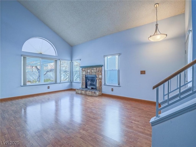 unfurnished living room featuring hardwood / wood-style floors, a fireplace, and a textured ceiling