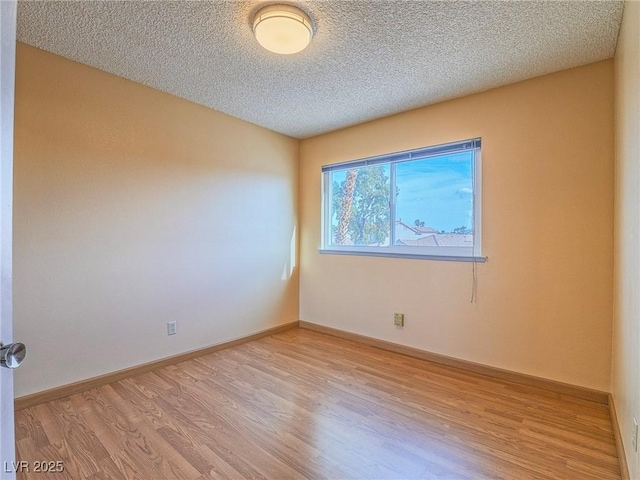 empty room with a textured ceiling and light wood-type flooring