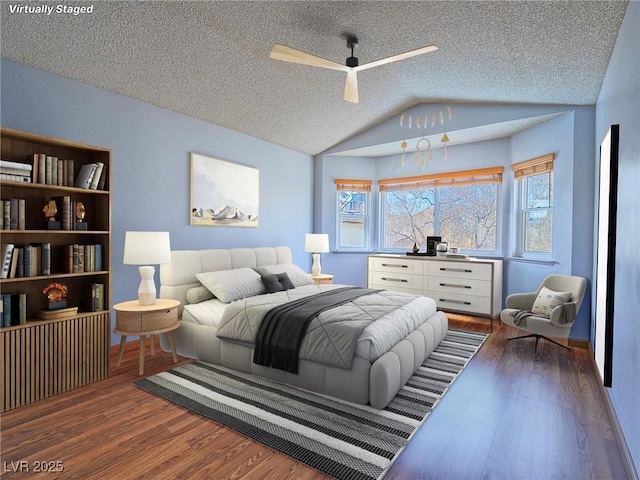 bedroom with dark hardwood / wood-style flooring, ceiling fan, vaulted ceiling, and a textured ceiling