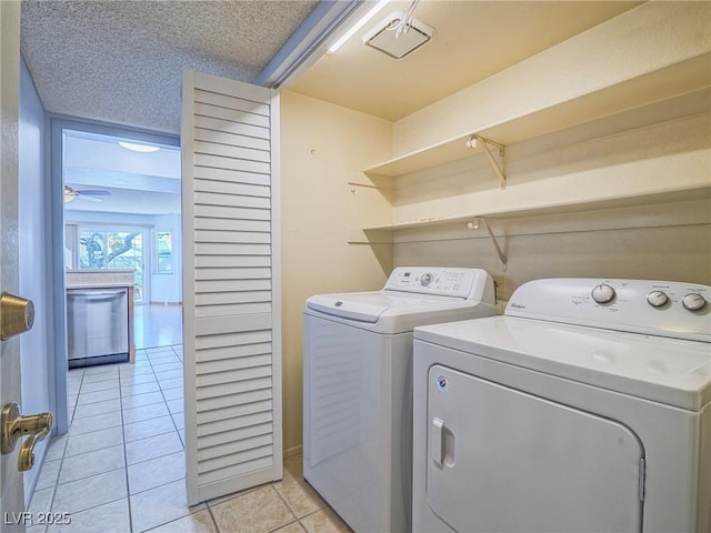 washroom featuring ceiling fan, separate washer and dryer, a textured ceiling, and light tile patterned floors