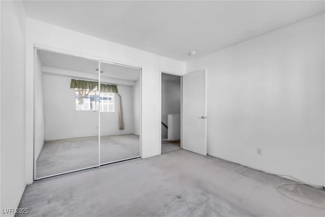 unfurnished bedroom featuring concrete flooring and a closet