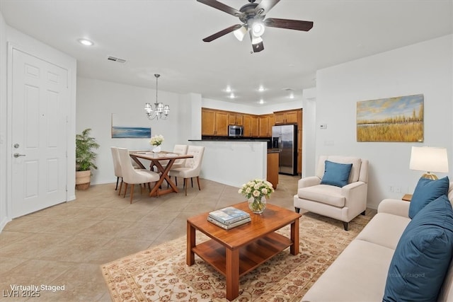 tiled living room featuring ceiling fan with notable chandelier