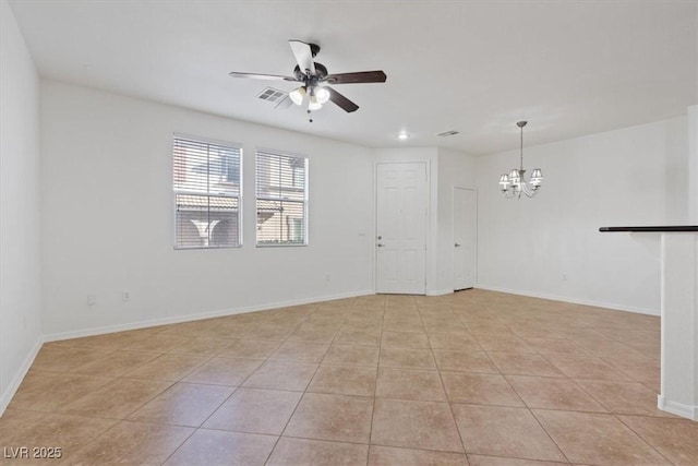 tiled spare room with ceiling fan with notable chandelier