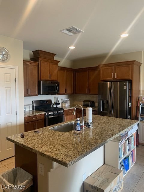 kitchen featuring appliances with stainless steel finishes, sink, a center island with sink, and a kitchen bar