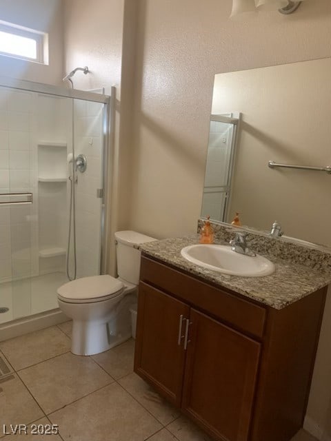 bathroom with tile patterned flooring, toilet, vanity, and walk in shower