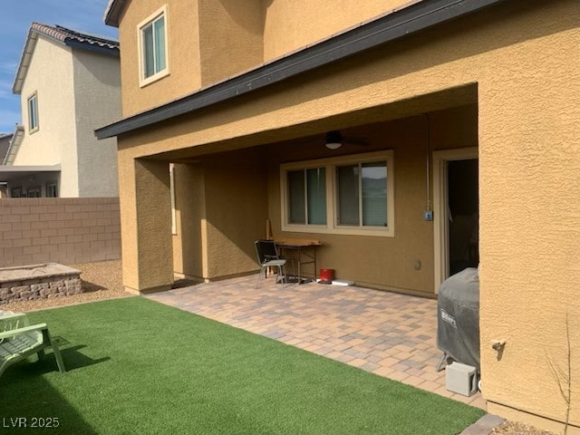 back of property with a lawn and a patio area