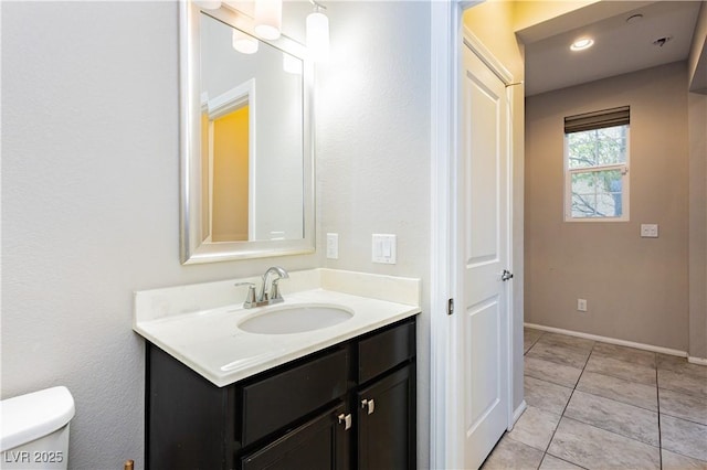 bathroom featuring vanity, tile patterned floors, and toilet