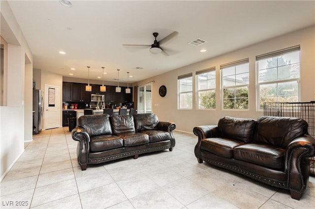 tiled living room with ceiling fan and plenty of natural light