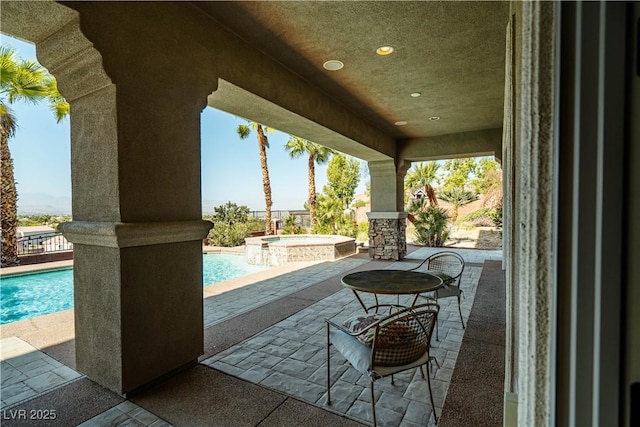 view of patio with a swimming pool with hot tub